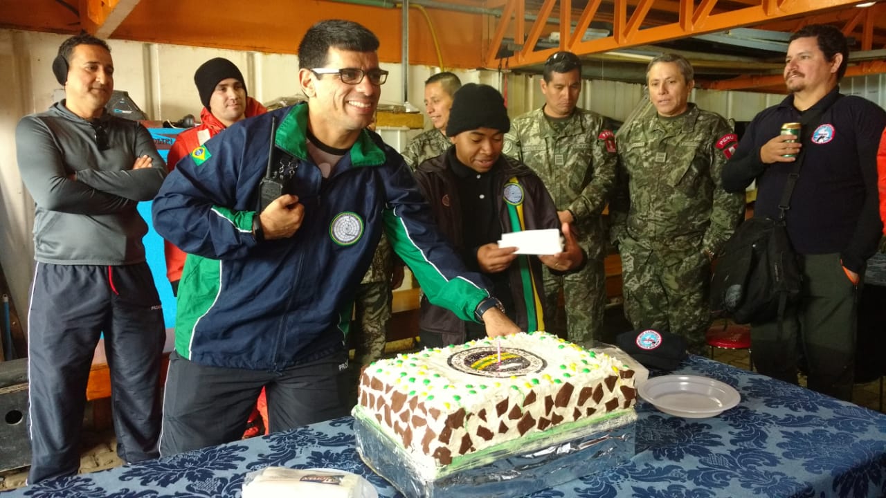 Pesquisadores celebram os 35 anos da Estação com bolo comemorativo em estação da Antártica